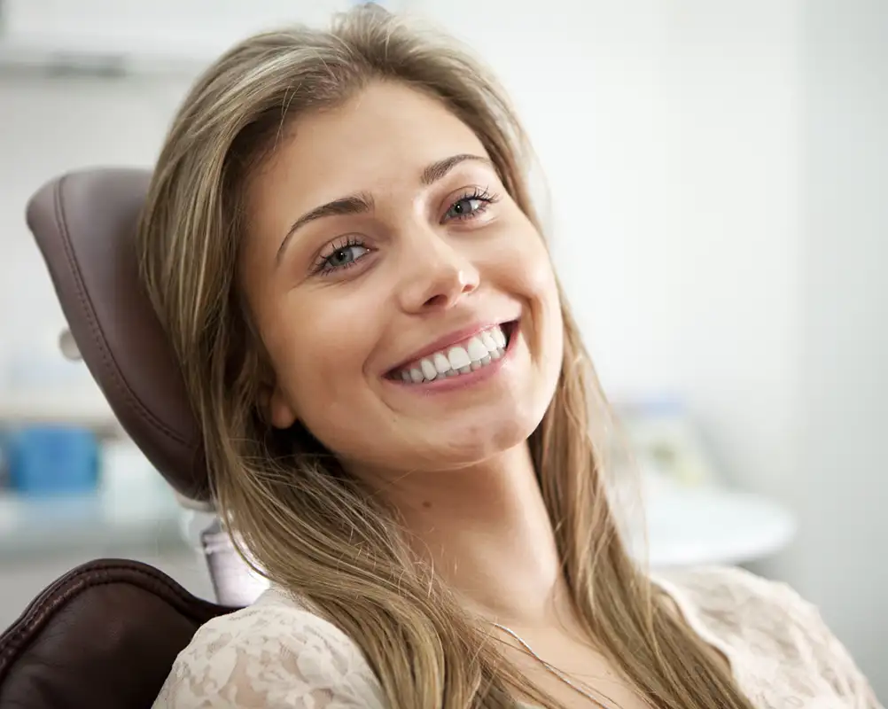 young adult woman smiling in a dentist chair